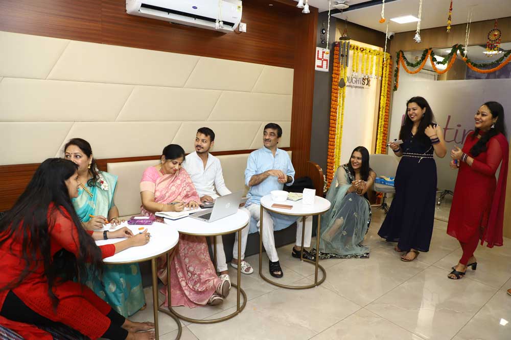 Some colleagues are sitting and talking during Diwali celebration in the office.