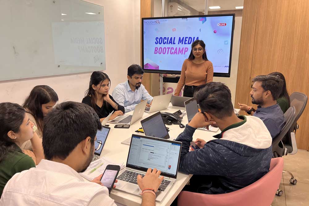 A girl is discussing a social media bootcamp with her colleagues in a meeting room